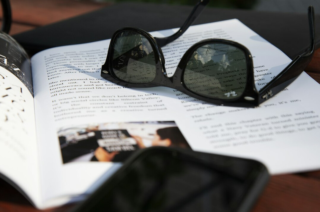 Open notebook with a pen and reading glasses on a table